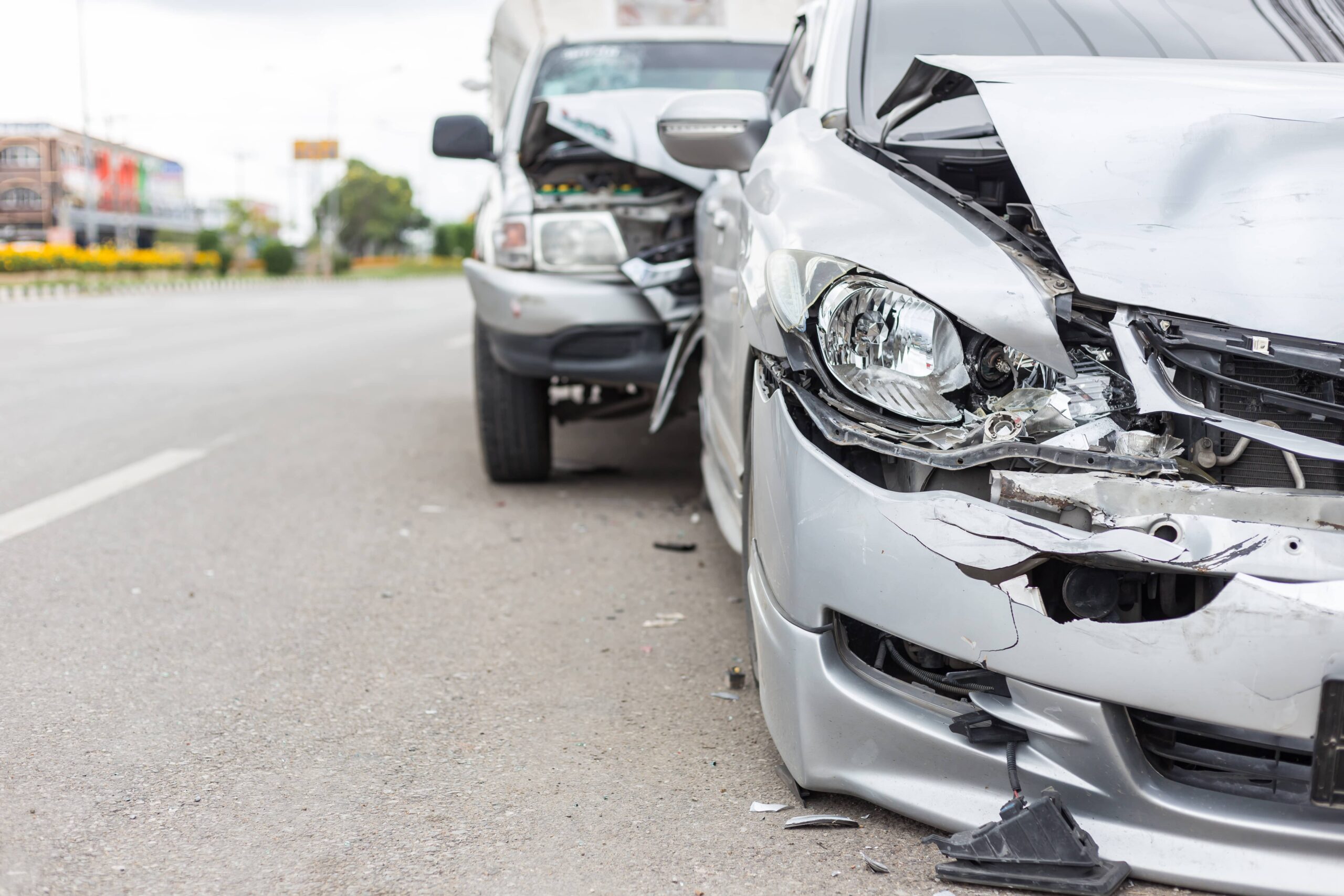 two damaged vehicles on the side of the road after a crash | Burg Simpson