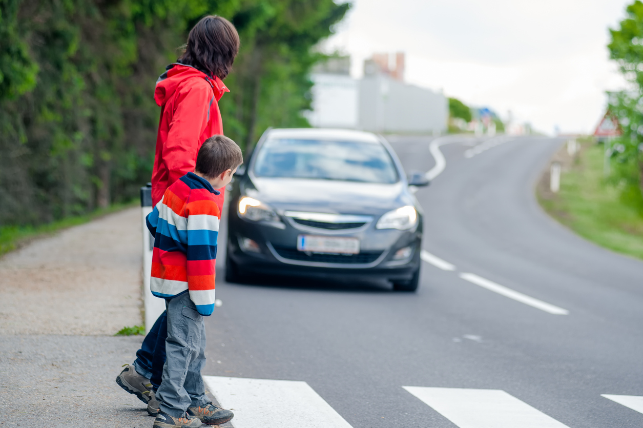Mother and sone crossing the street at a crosswalk