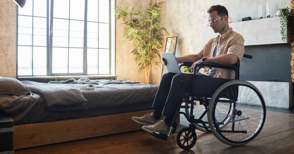 Man in wheelchair reviewing personal injury settlement offer | Burg Simpson