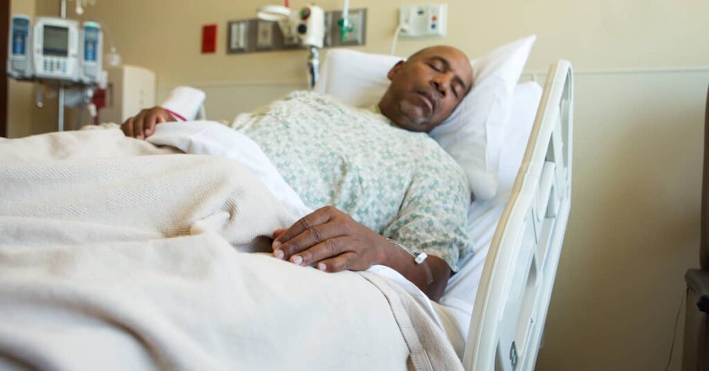 African American man sick in hospital bed | Burg Simpson