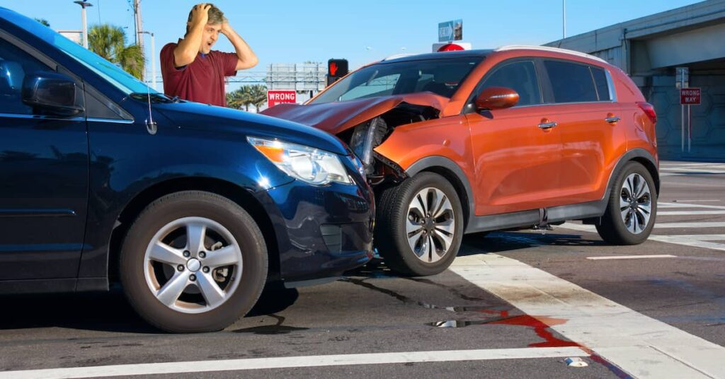 Man holding his head in shock after a car accident in an intersection | Burg Simpson