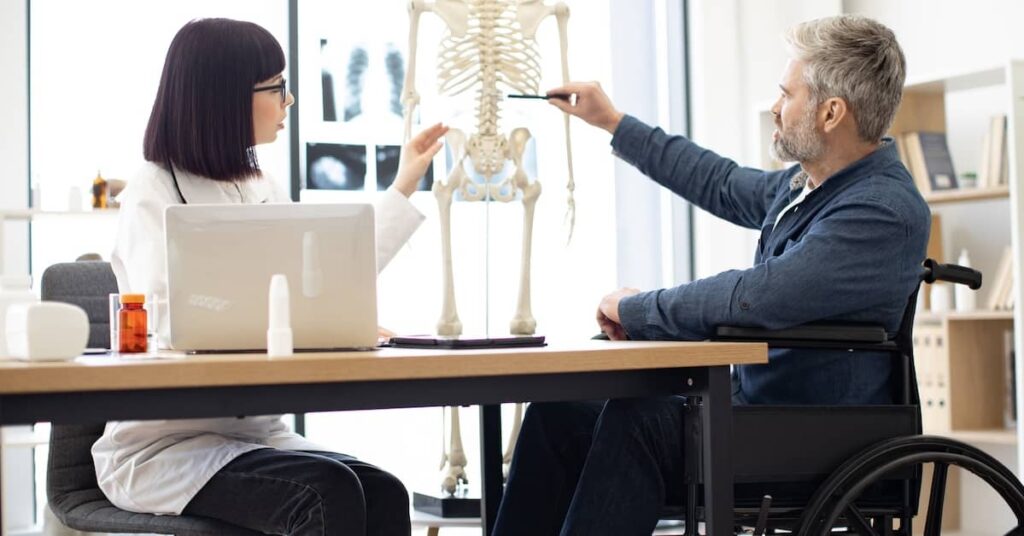 Female doctor explaining spinal injury to paralyzed male patient | Burg Simpson