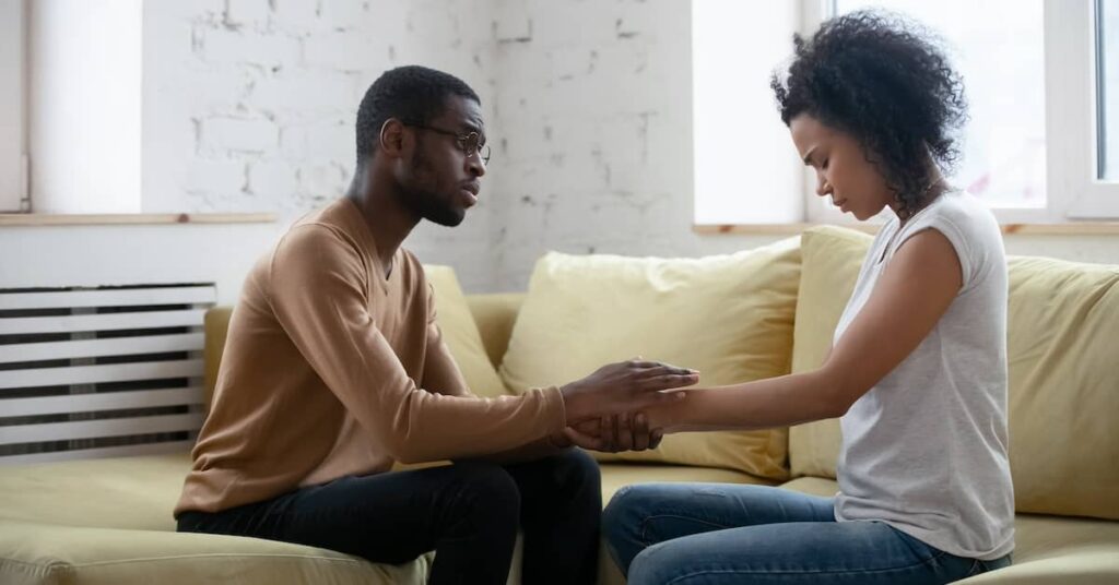 African American man comforting upset woman | Burg Simpson