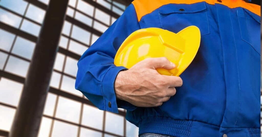 Construction worker holding a hardhat | Burg Simpson