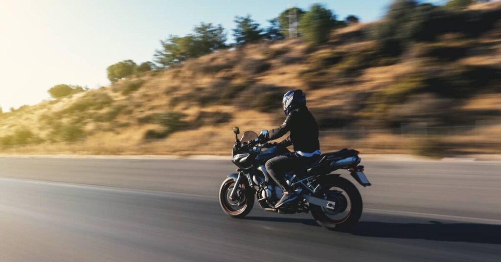 Motorcyclist riding along Arizona highway | Burg Simpson