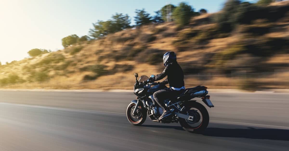 Motorcyclist riding along Arizona highway | Burg Simpson