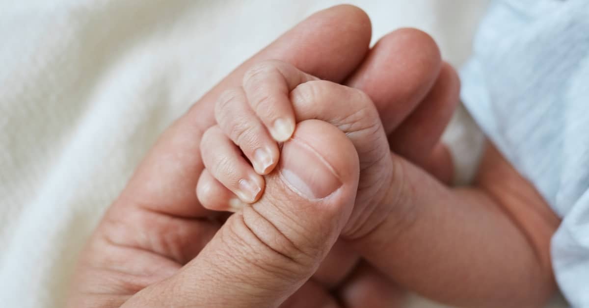 Baby grabbing onto father's hand | Burg Simpson