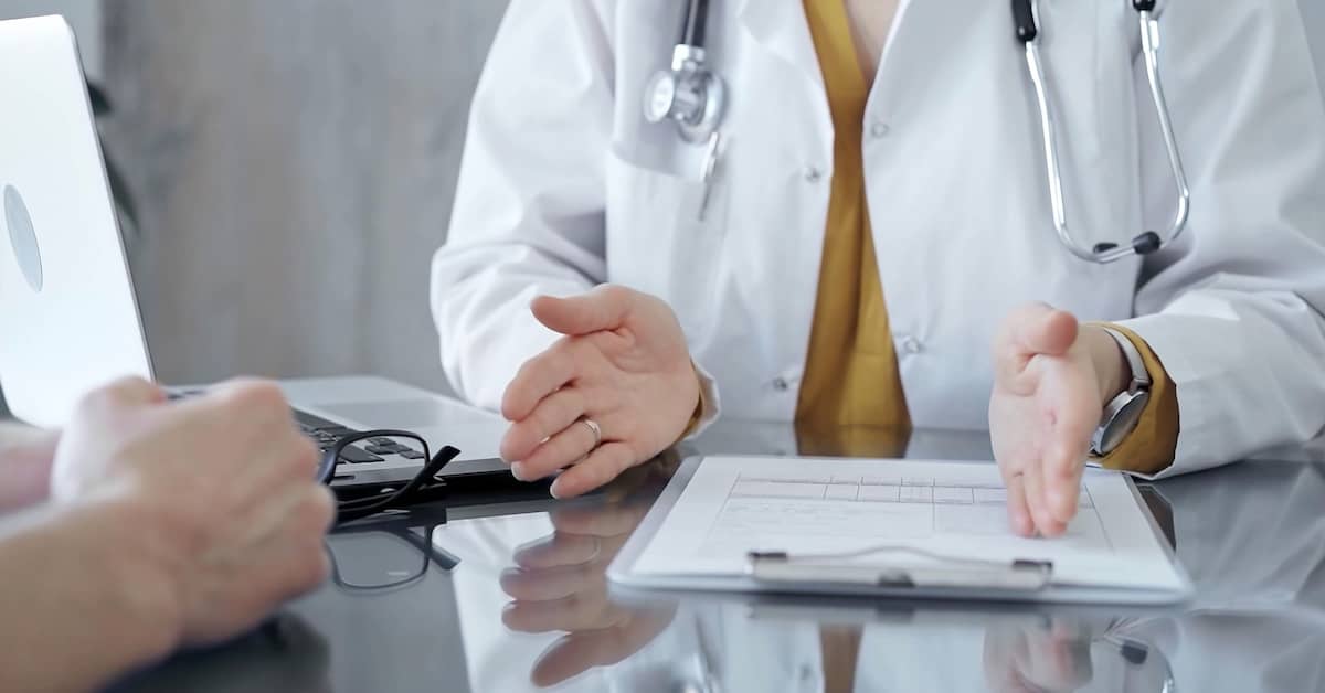Doctor discussing a patient's care | Burg Simpson