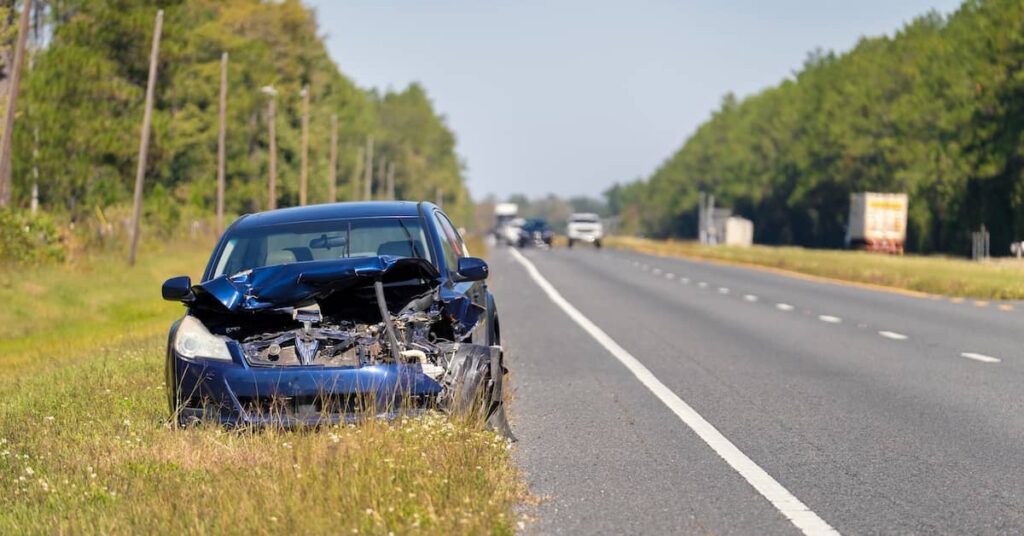 Damaged car on the side of the road after a car accident | Burg Simpson