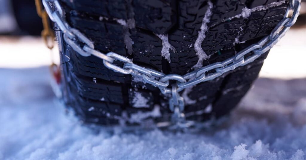 Chains equipped on a truck driver on a snowy road | Burg Simpson