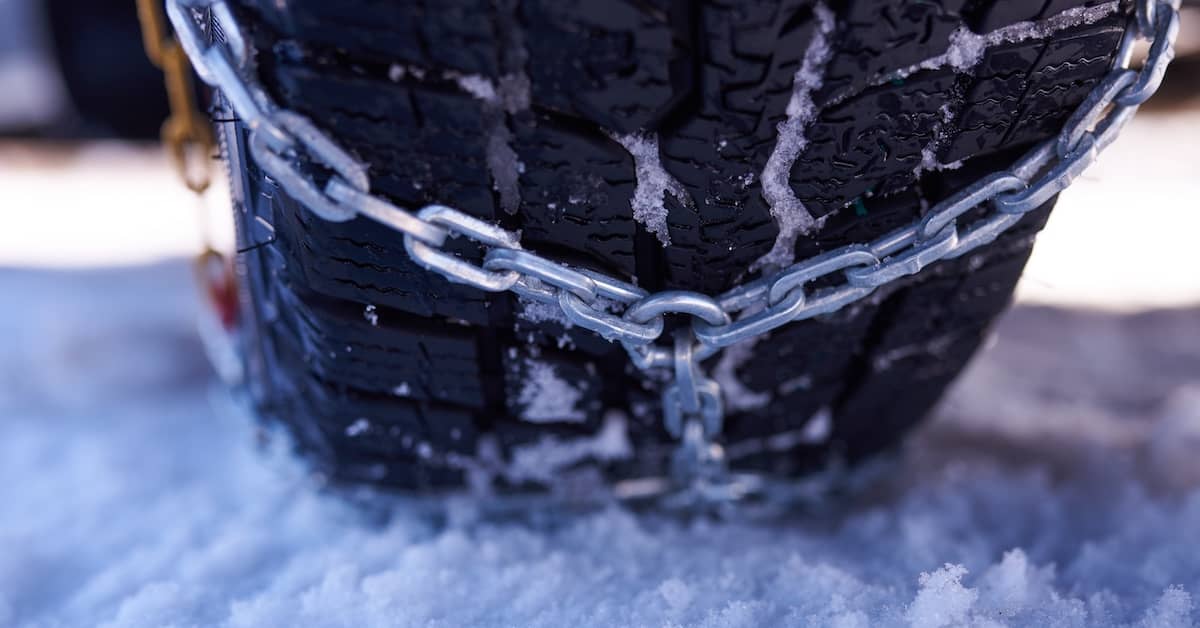 Chains equipped on a truck driver on a snowy road | Burg Simpson