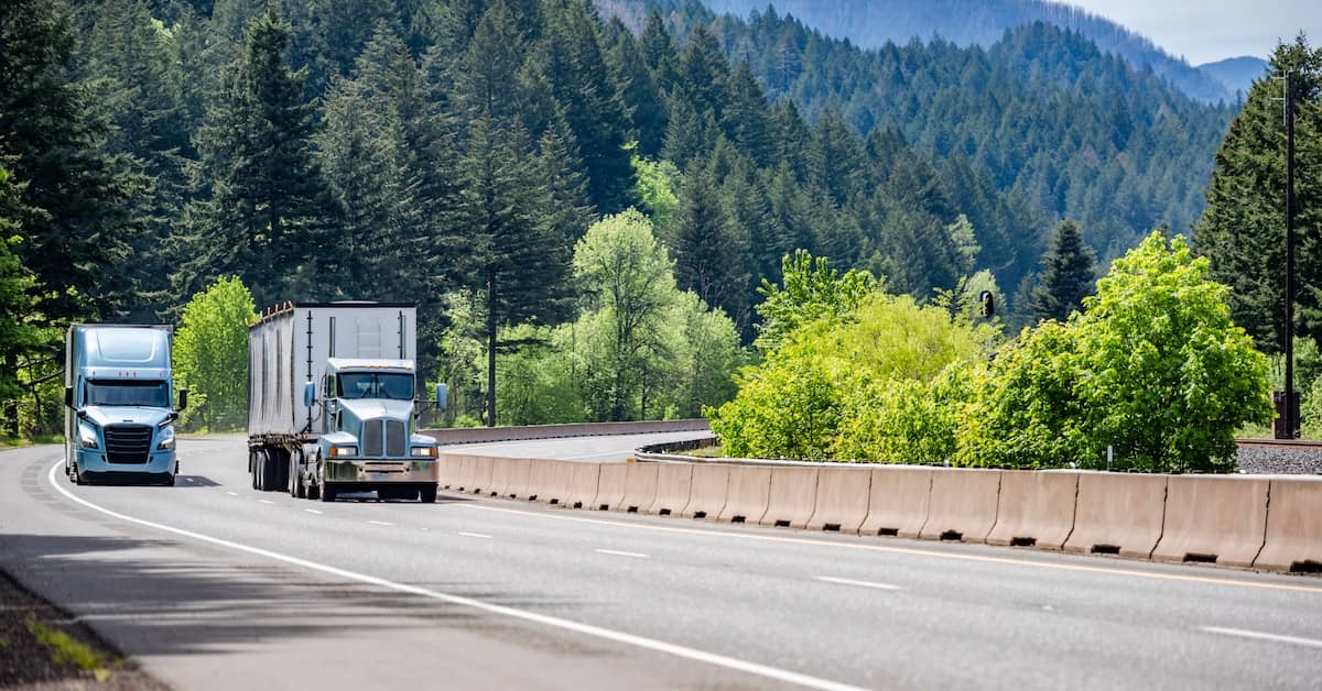 Commercial truck overtaking another on an interstate highway | Burg Simpson