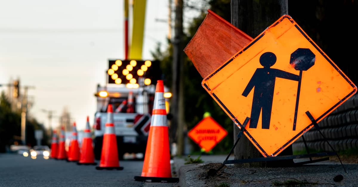 Construction zone with warning sign and traffic cones | Burg Simpson