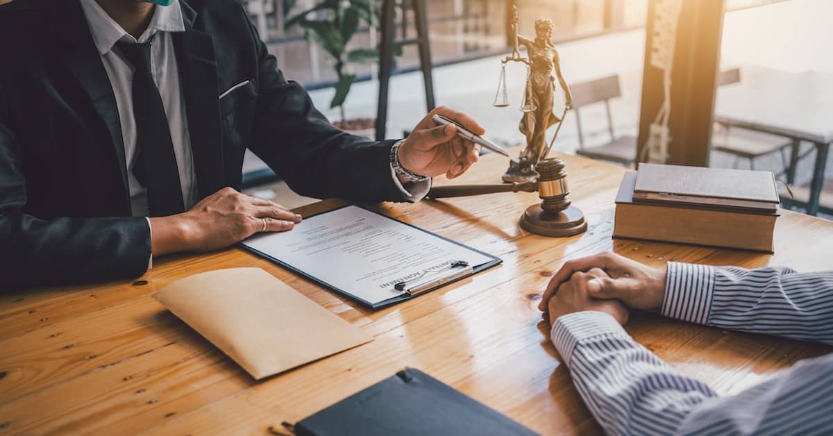 Tractor-trailer accident lawyer reviewing terms of a settlement with a client | Burg Simpson