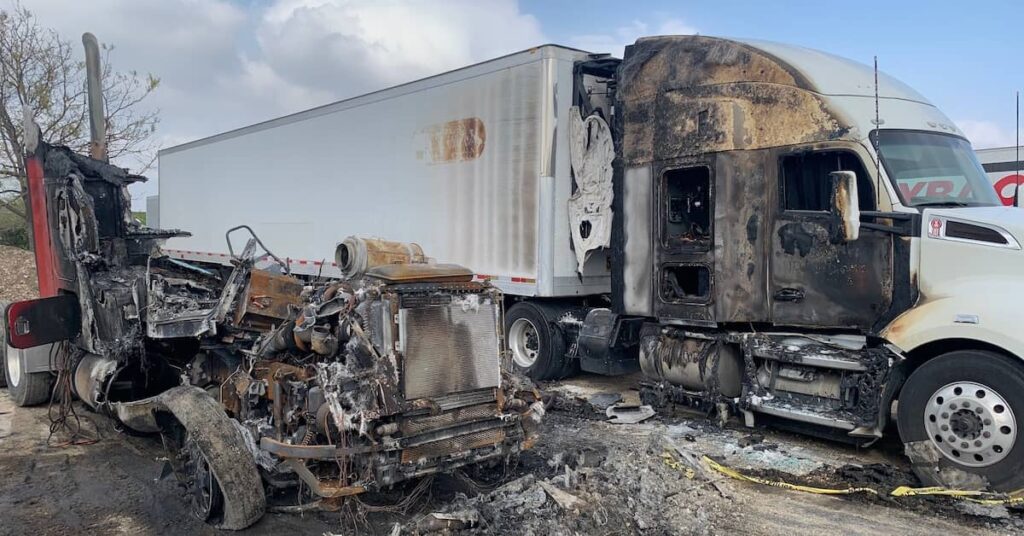 Burnt semi truck and a destroyed vehicle in a parking lot after a fiery crash | Burg Simpson