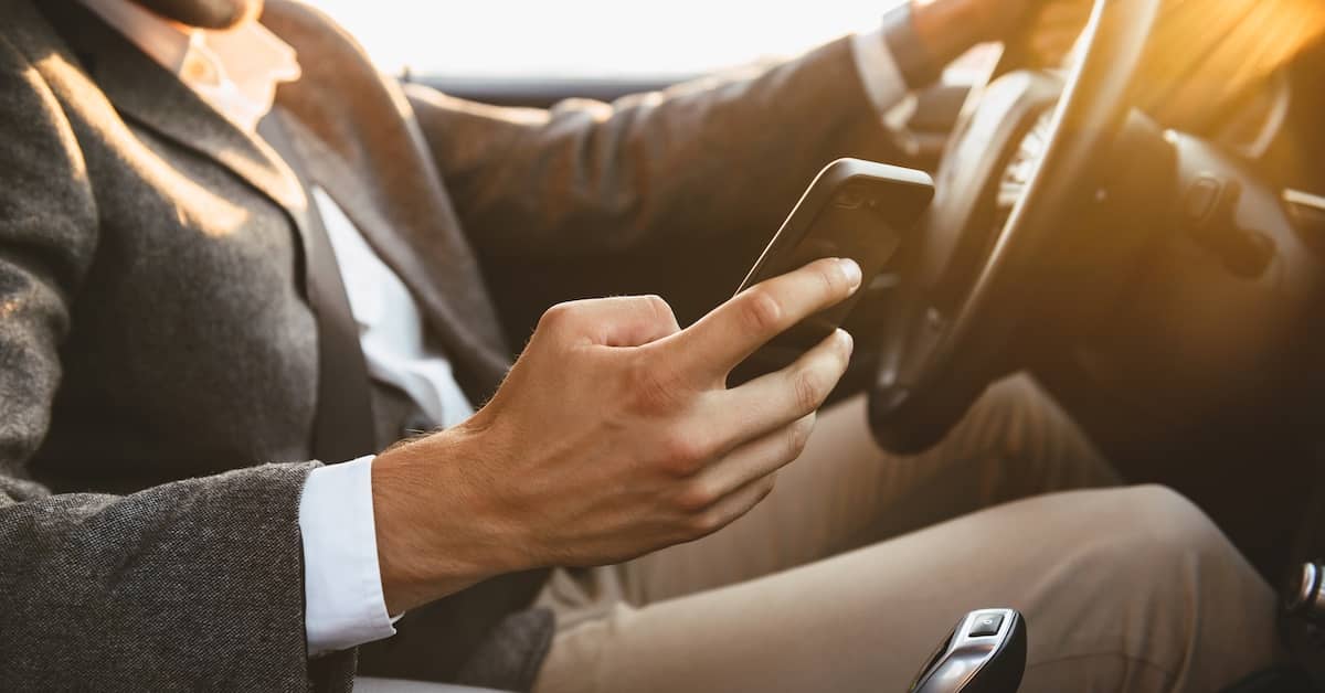 Distracted driver texting while driving behind the wheel | Burg Simpson