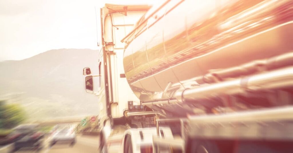 Speeding tanker truck on a highway with other cars | Burg Simpson