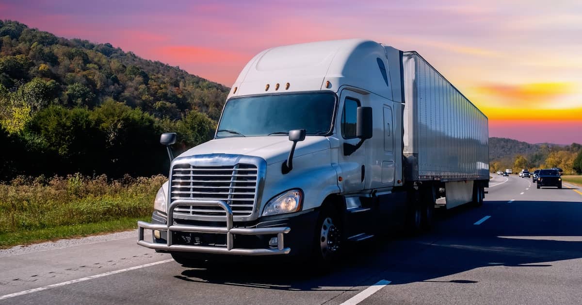 Speeding truck on a highway at dusk | Burg Simpson