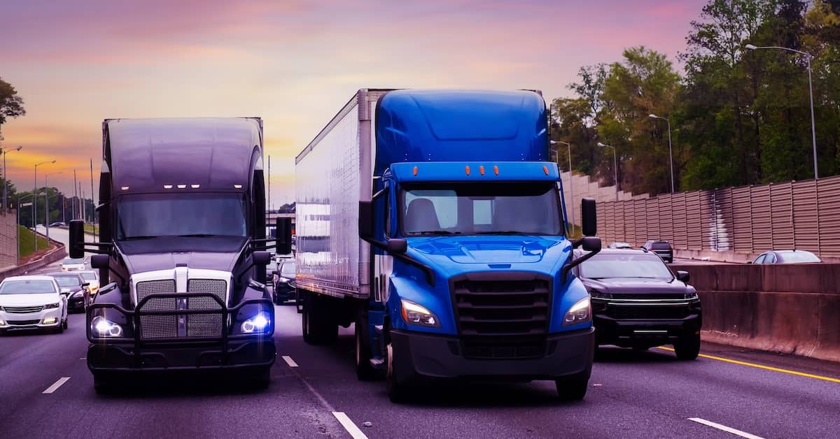 Semi-trucks riding two abreast on a busy highway | Burg Simpson