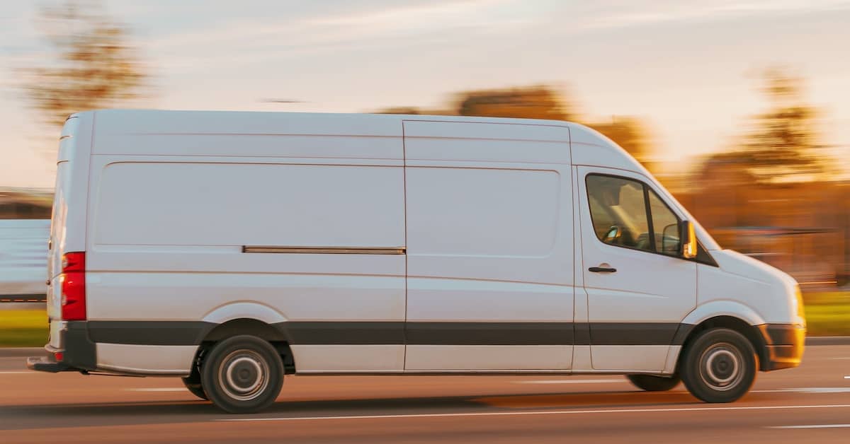 Delivery truck driving fast down the street | Burg Simpson